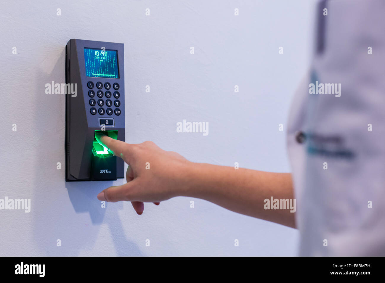 Nurse's finger being scanned by a fingerprint scanner. Stock Photo