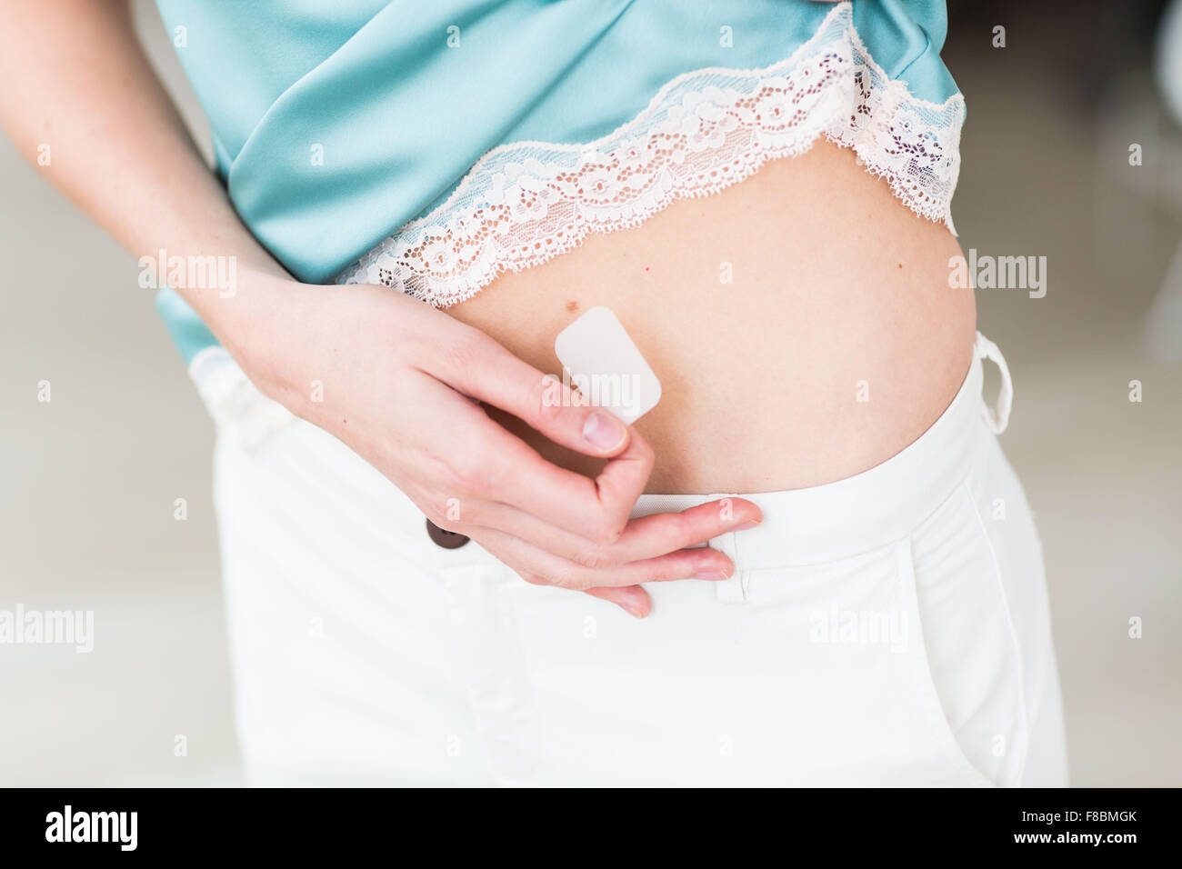 Woman applying a patch. Stock Photo