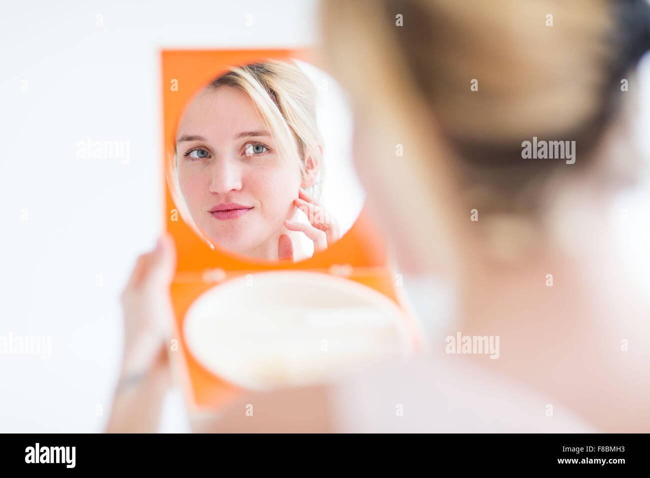 Woman checking her face in the mirror Stock Photo Alamy