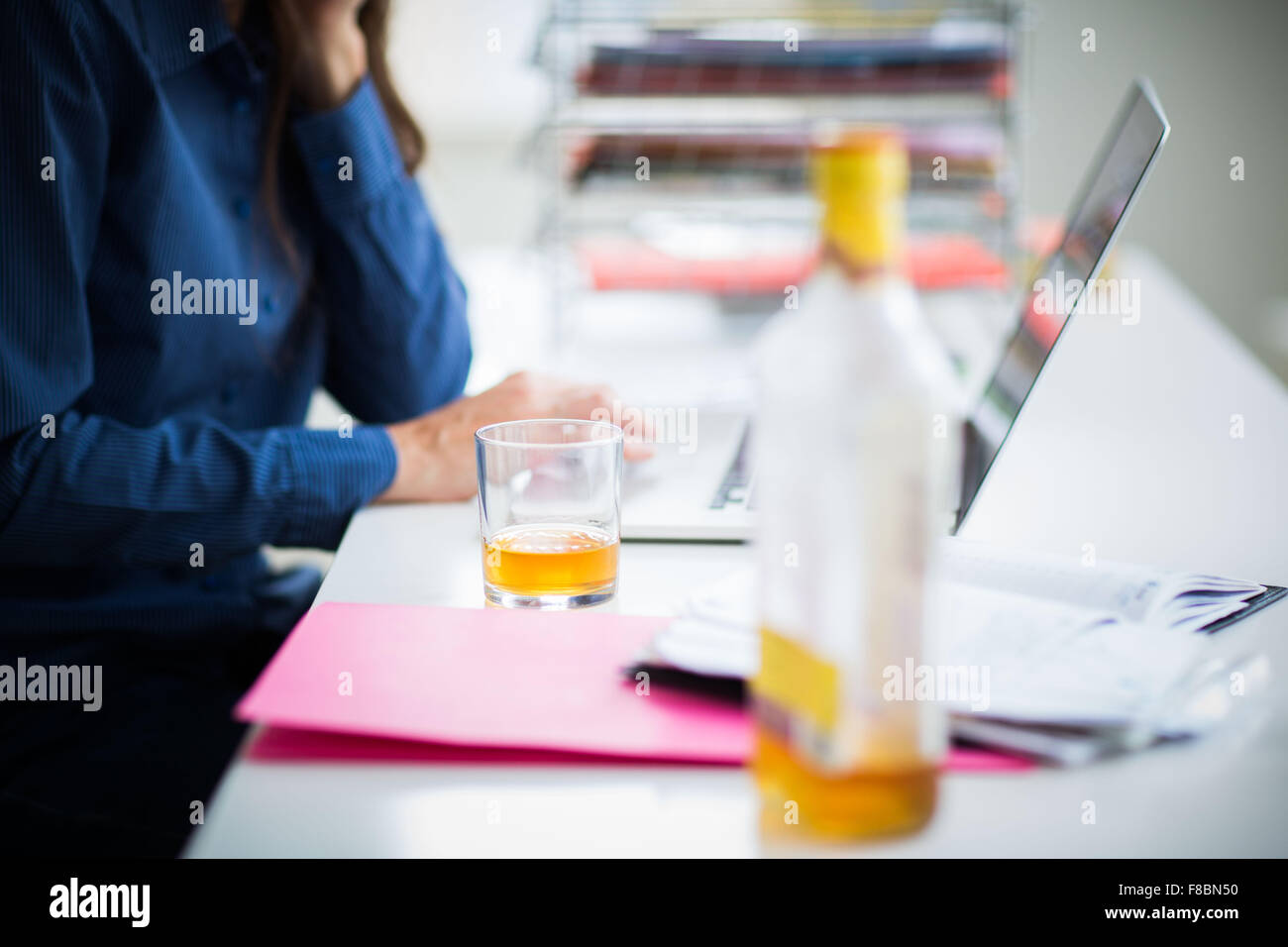 Office worker drinking alcool. Stock Photo
