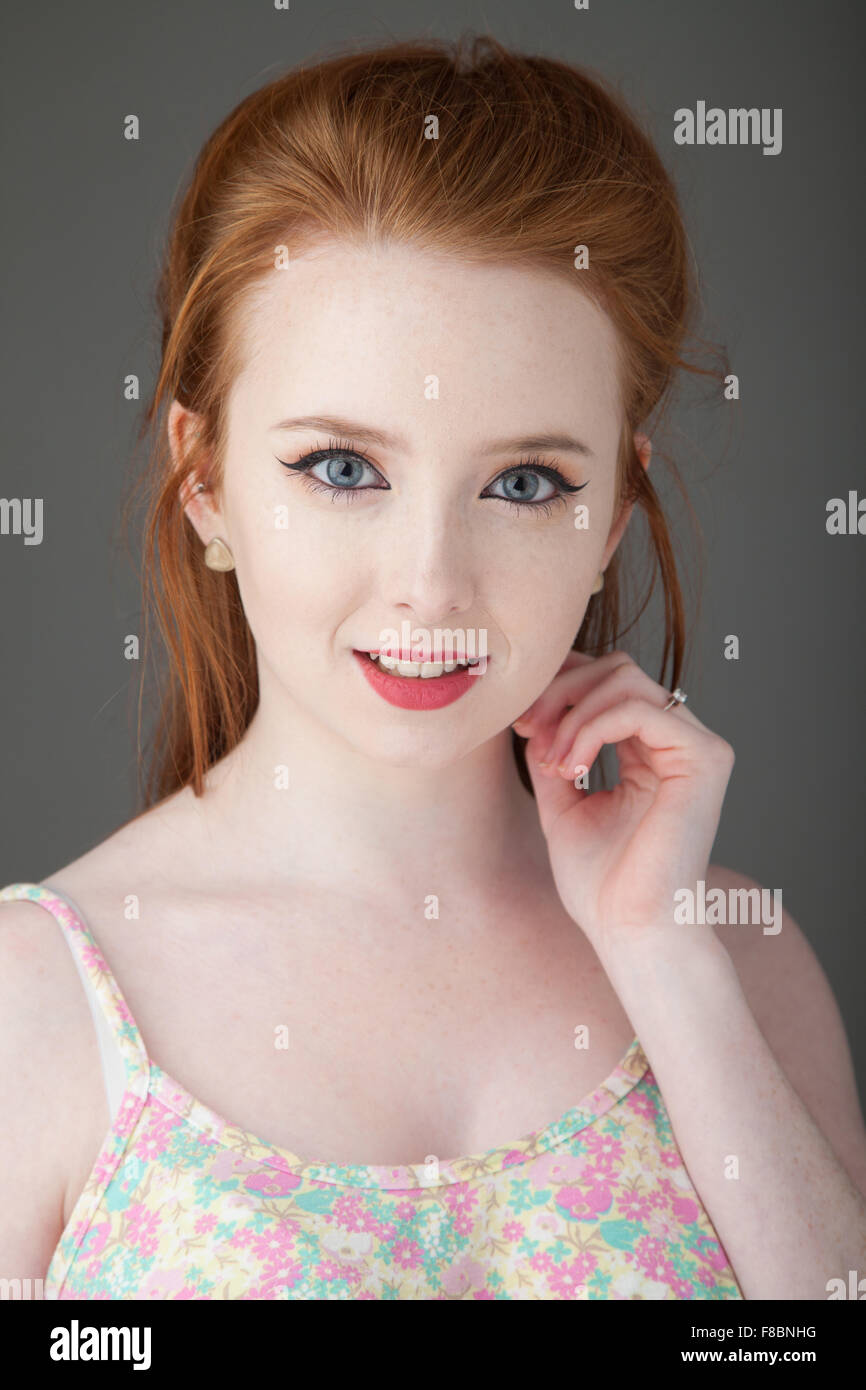 Pretty redheaded woman with pale skin looking towards camera. Stock Photo