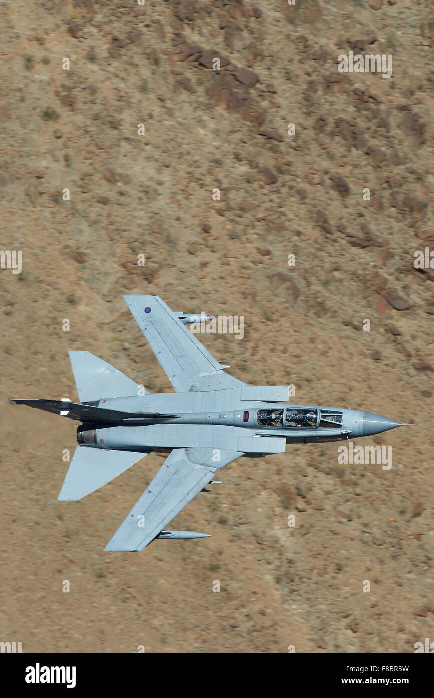 Royal Air Force Tornado GR4 Jet Fighter Flying Close To The Terrain In A Desert Valley. Stock Photo