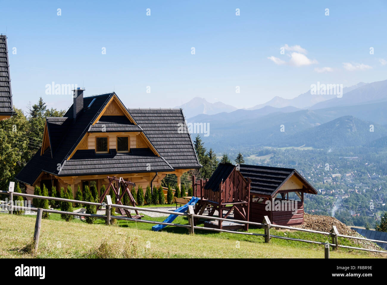 Traditional alpine wooden house overlooking High Tatra Mountains above the town. Gubałowka Hill, Zakopane, Tatra County, Poland, Stock Photo