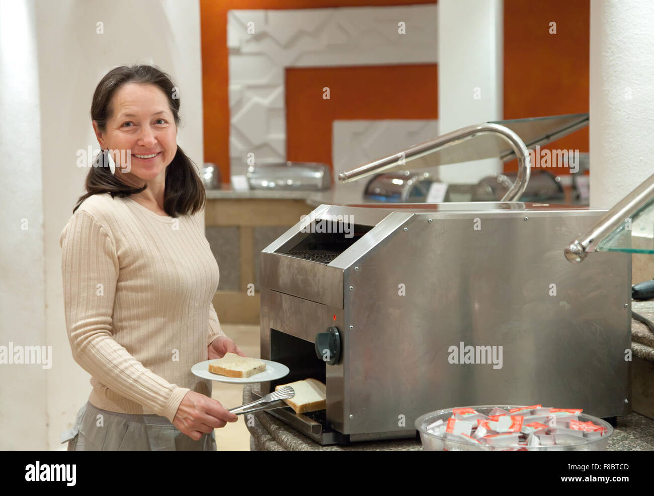 woman makes toast in toaster at hotel restaurant Stock Photo Alamy