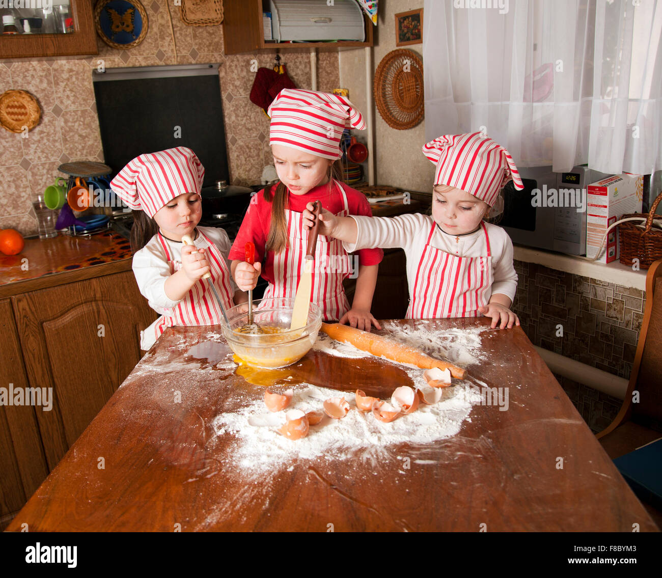 Two Cooks Create Mess Three little chefs enjoying in the kitchen making big mess. Litt Stock ...