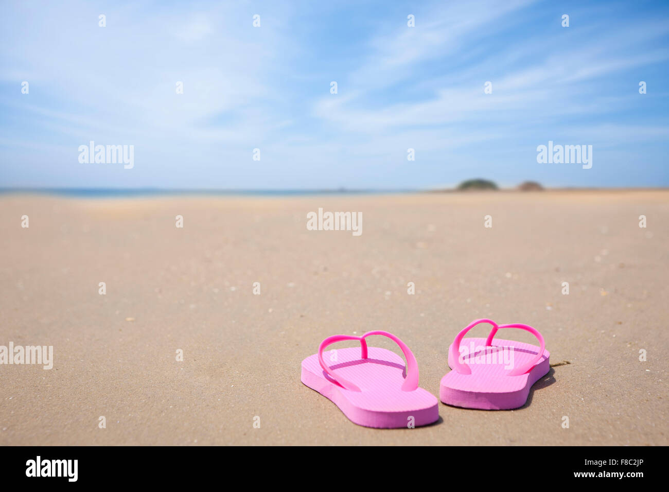 Copy space with pink flip flops on sand at beach Stock Photo - Alamy