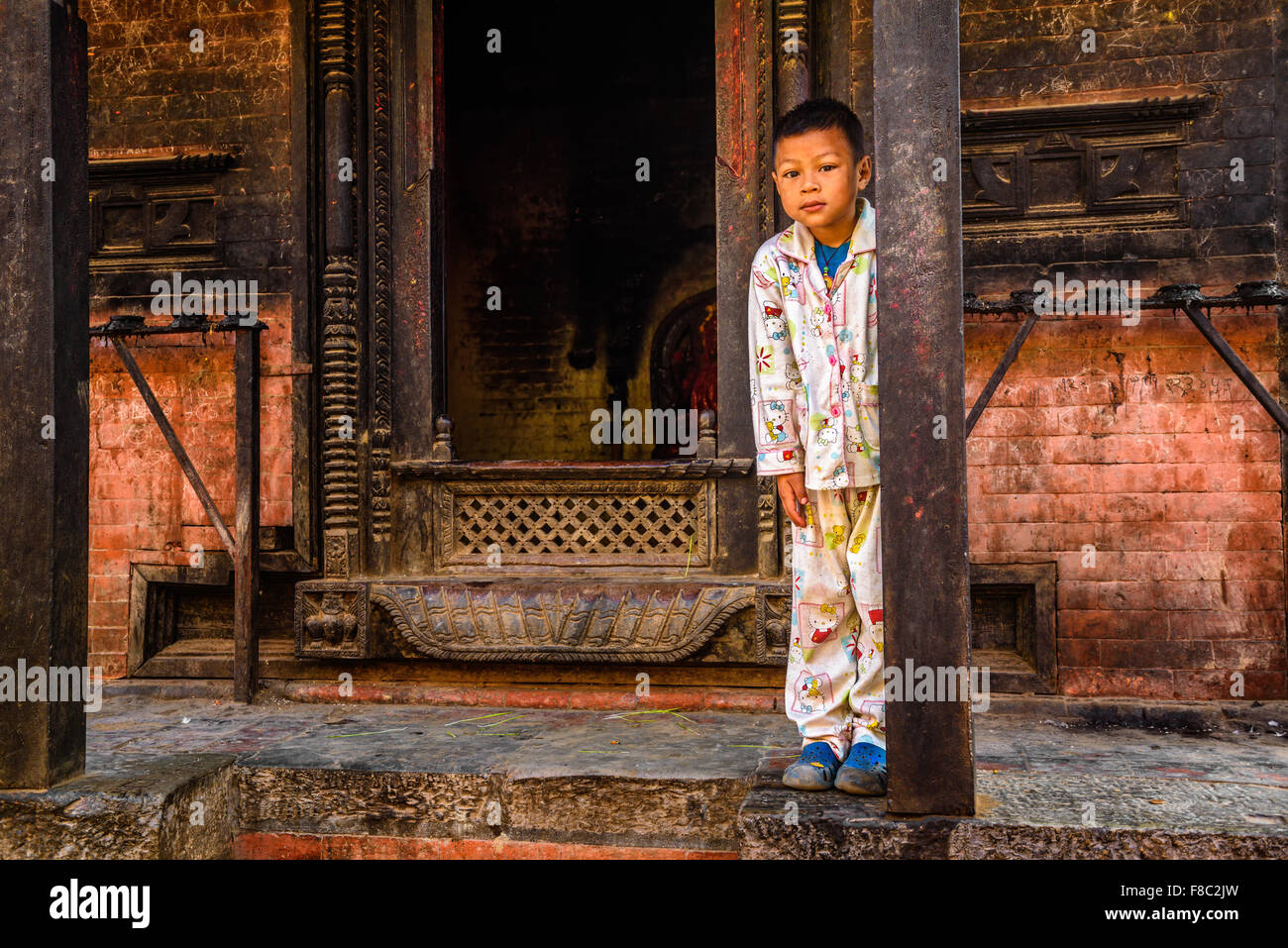 Small boy in pajamas stands in front of his home Stock Photo