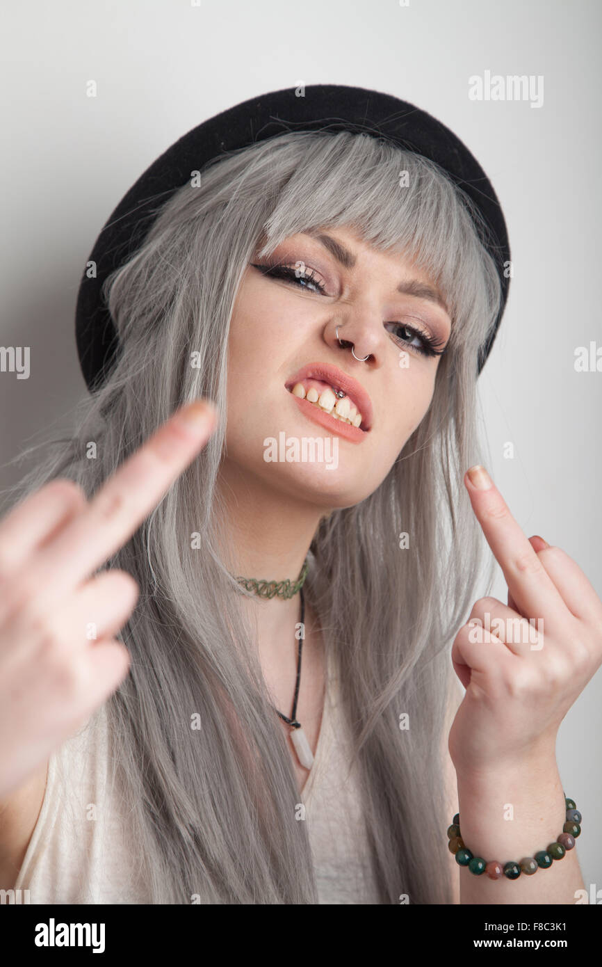 Teenage girl giving the middle finger towards the camera. Stock Photo