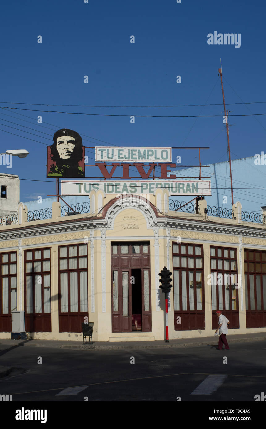 A street corner in Cienfuegos with an image of Che Guevara on a building and the quote 'your example lives, your ideas endure' Stock Photo