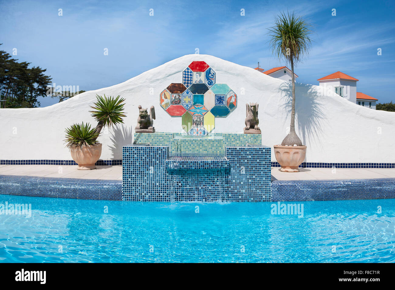 Outdoor swimming pool with flowerpots under a blue sky Stock Photo