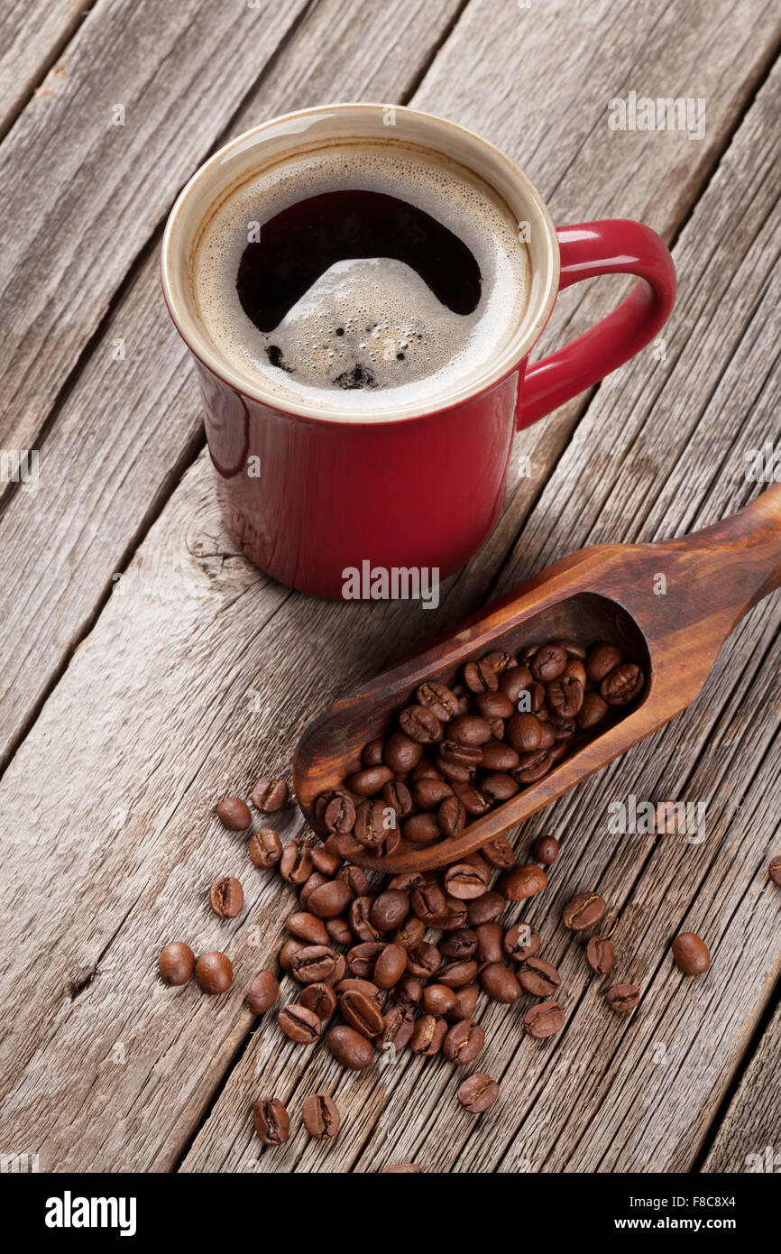 Coffee cup and beans on old wooden table Stock Photo - Alamy