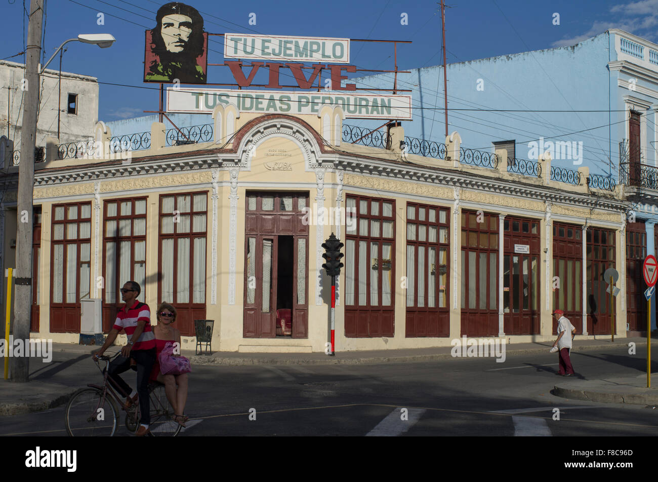 A street corner in Cienfuegos with an image of Che Guevara on a building and the quote 'your example lives, your ideas endure' Stock Photo