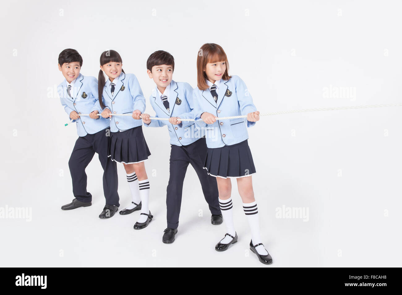Uniform Rope Four elementary students in school uniforms holding a rope together and ...