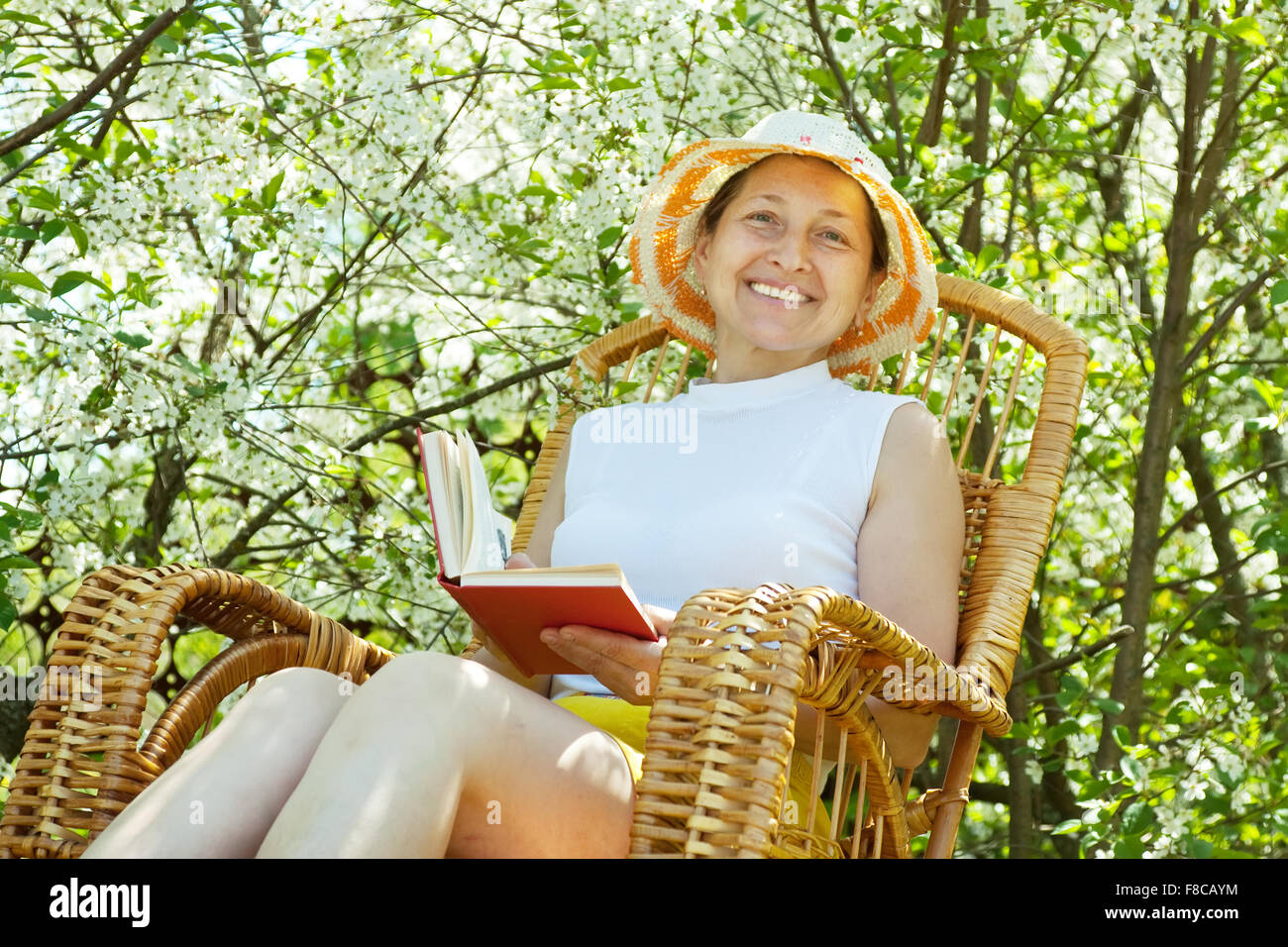 Happy mature woman relaxing in bloom garden Stock Photo - Alamy