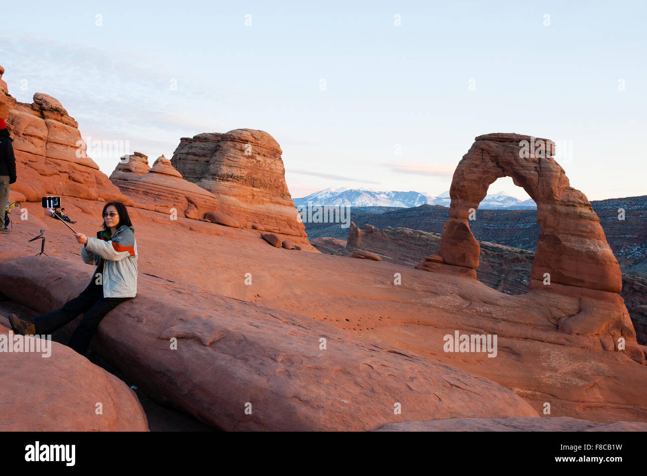Arches National Park, Utah, USA. A female tourist takes a selfie in front of Delicate Arch. Stock Photo