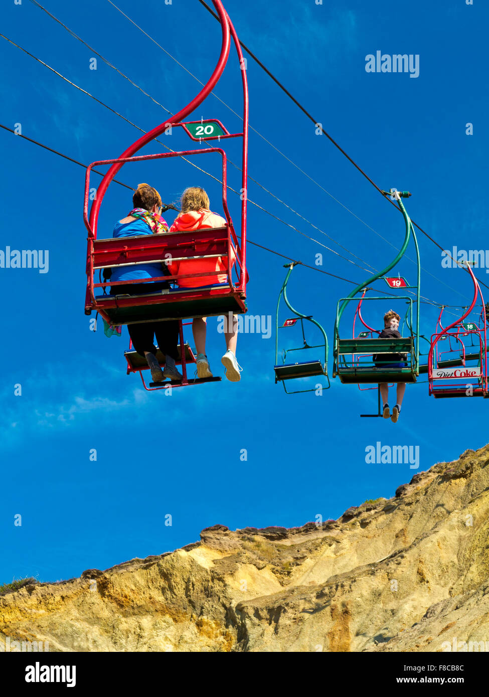 Tourists on chairlift at Alum Bay on the western tip of the Isle of Wight England UK famous for multicoloured sandstone cliffs Stock Photo