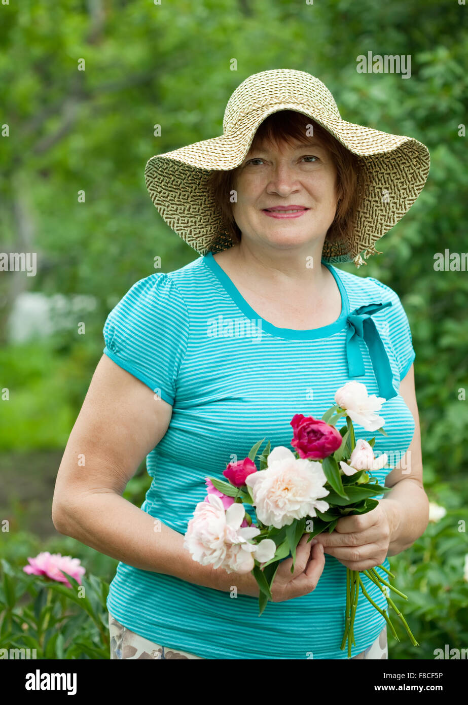 Happy mature woman with flowers bouquet at garden Stock Photo - Alamy