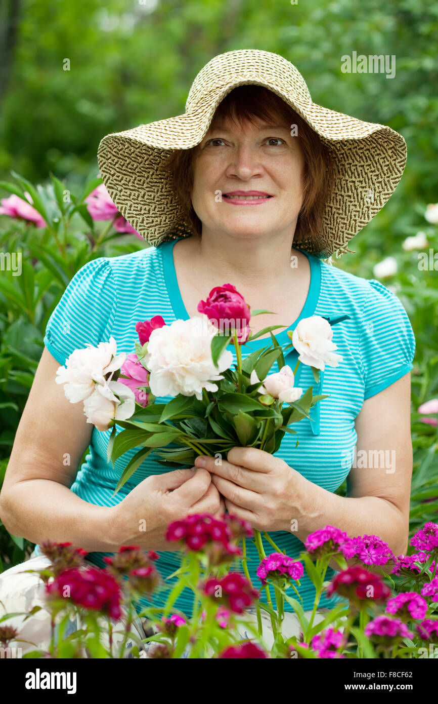 Happy mature woman with flowers at garden Stock Photo - Alamy