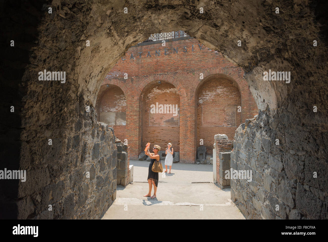 Women tourists, view of two female tourists visiting the remains of the roman amphitheatre in the historic centre of Catania, Sicily. Stock Photo
