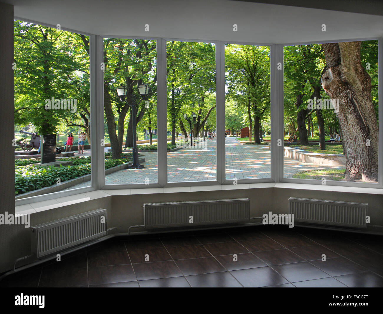 plastic windows overlooking the city park with big trees Stock Photo