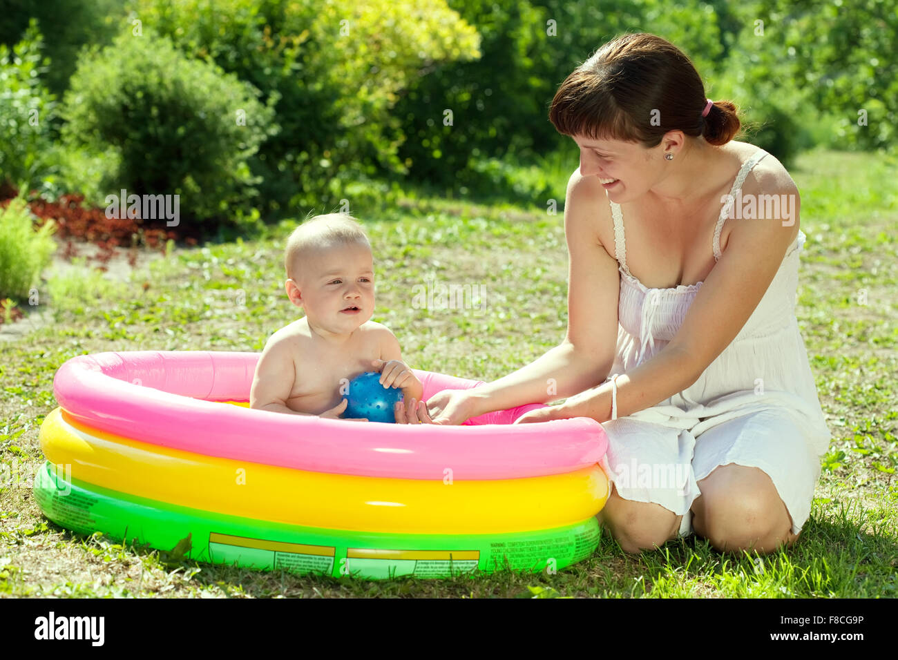 Happy baby swimming in kid inflatable pool with mother Stock Photo - Alamy