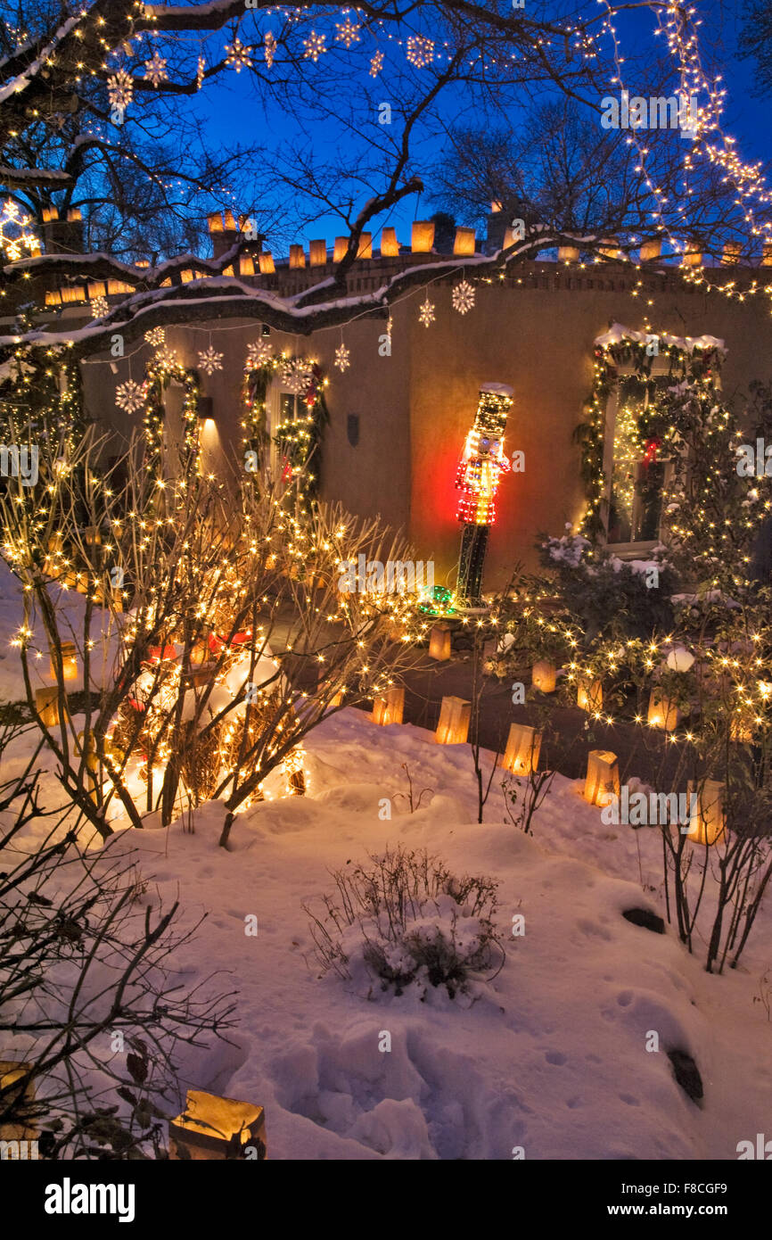 Paper bag faralitos and twinkling lights in the trees adorn a Santa Fe home on Canyon Road. Stock Photo