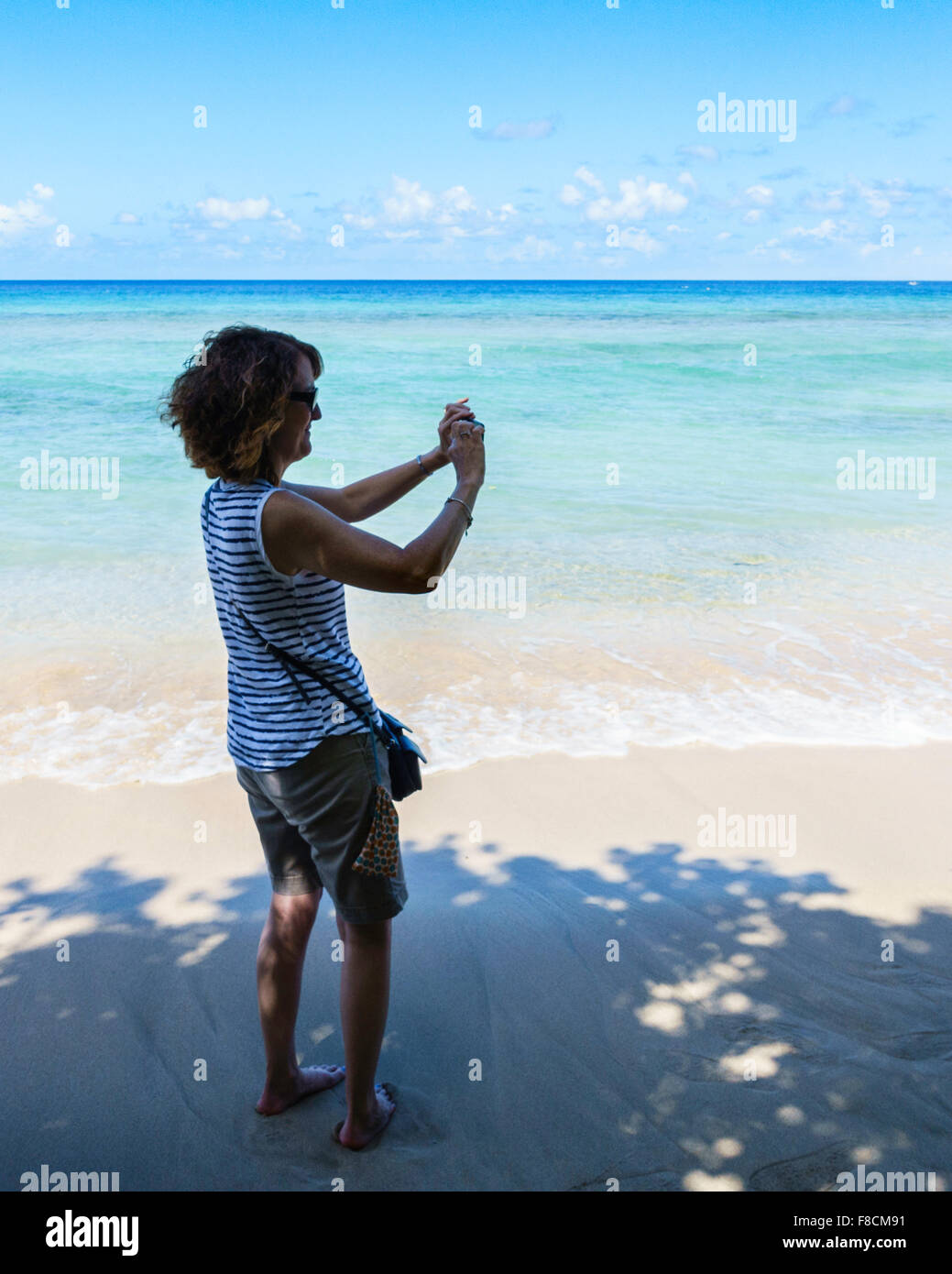 A 50 year old woman photographs the beauty of the Caribbean in St. Croix, U.S. Virgin Islands. Stock Photo