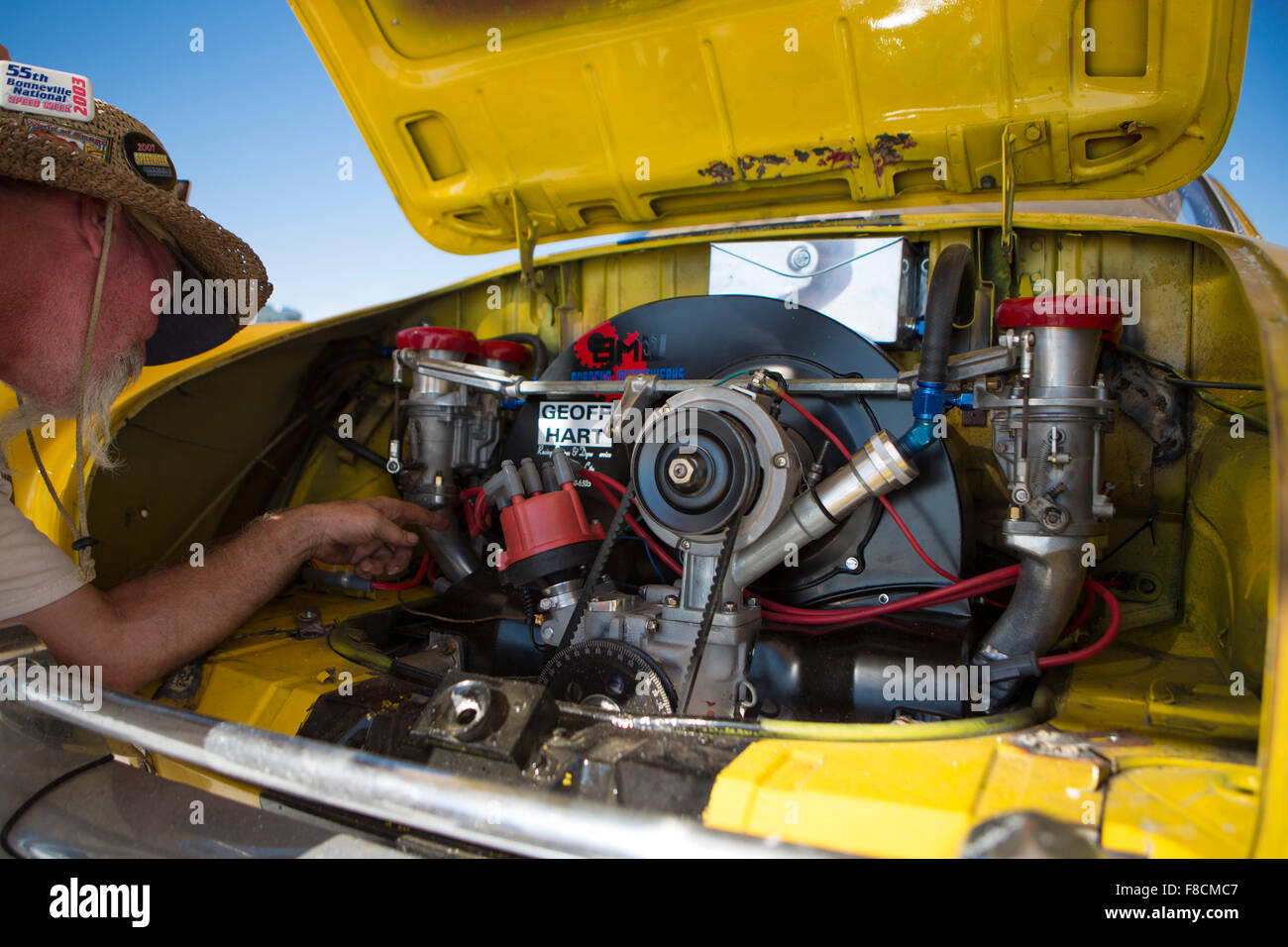 Mechanic working on engine parts of his speed yellow car Stock Photo