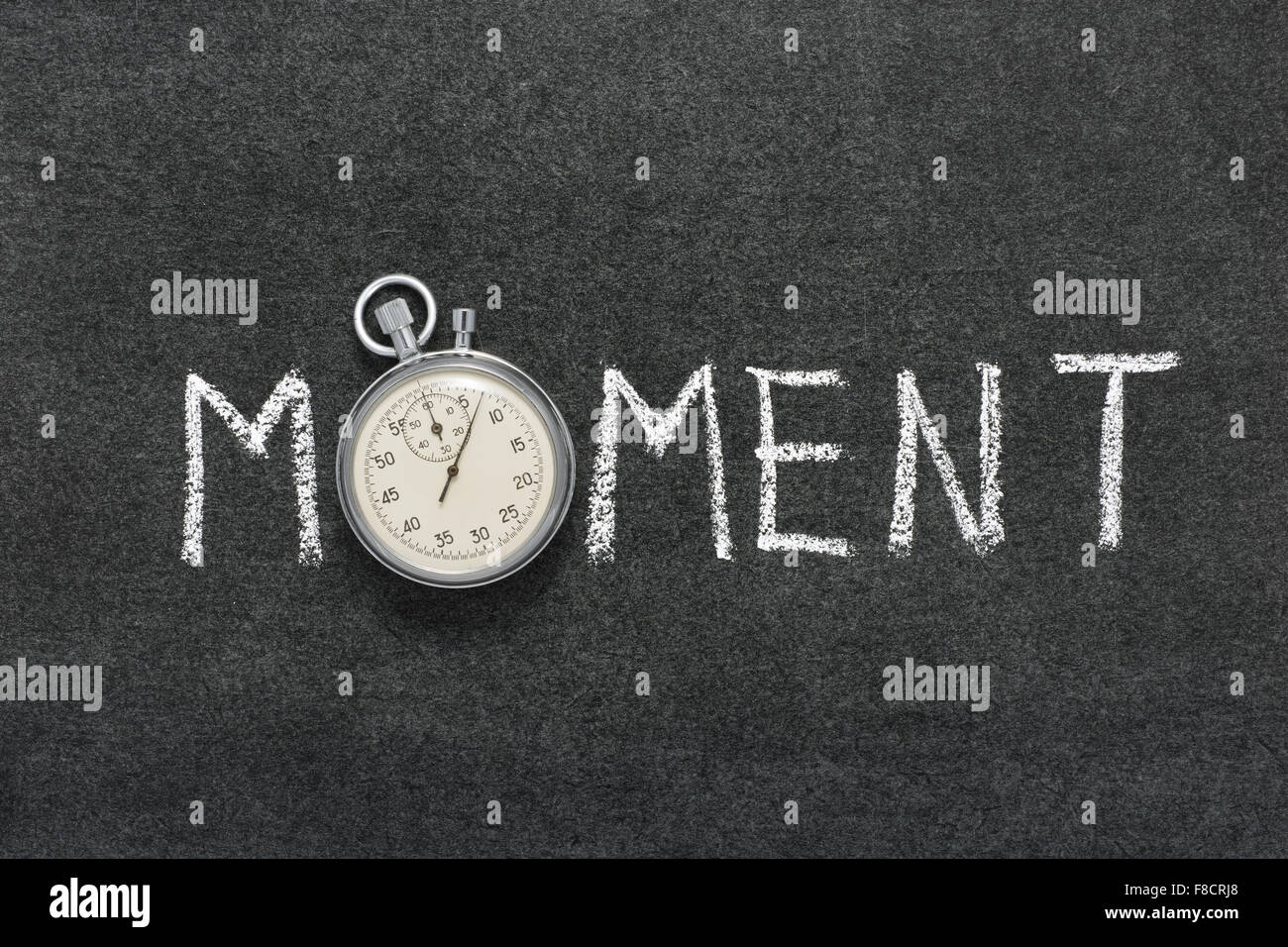 moment word handwritten on chalkboard with vintage precise