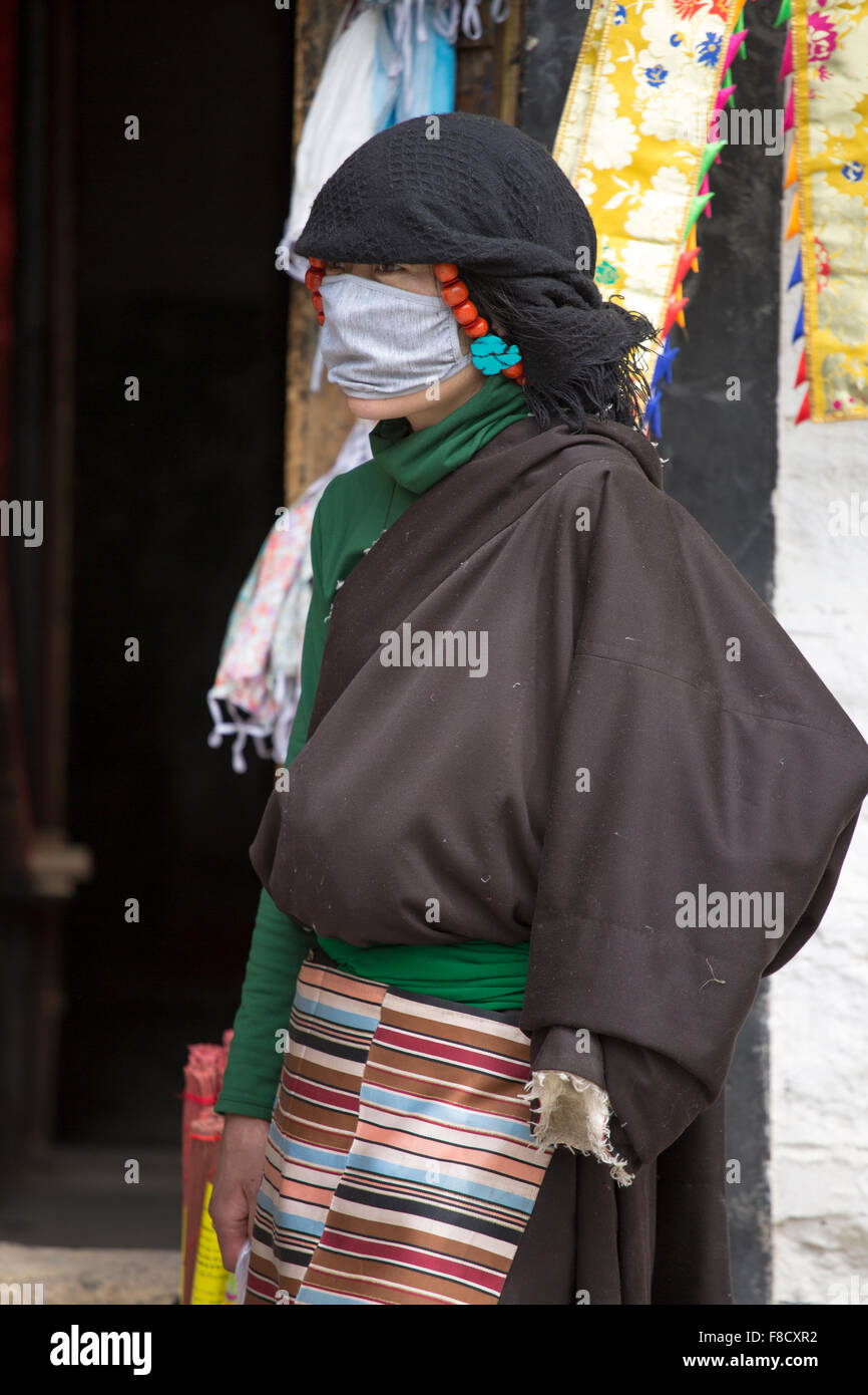 Tibetan woman dressed with traditional clothes in Lhas, Tibet. Stock Photo