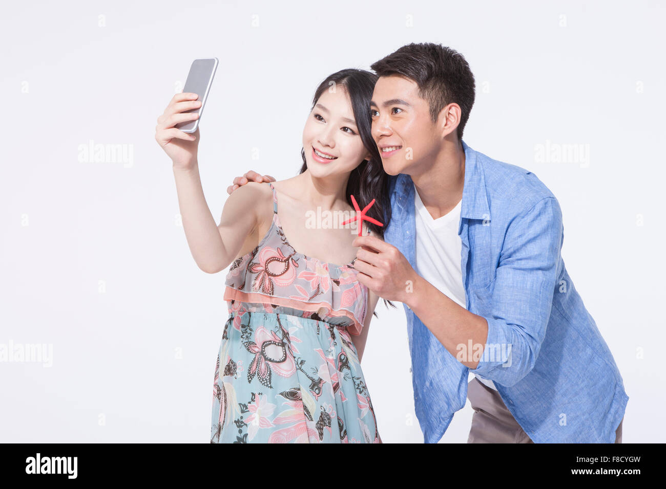 Couple in casual wear taking a self photo together with a starfish in man's hand Stock Photo