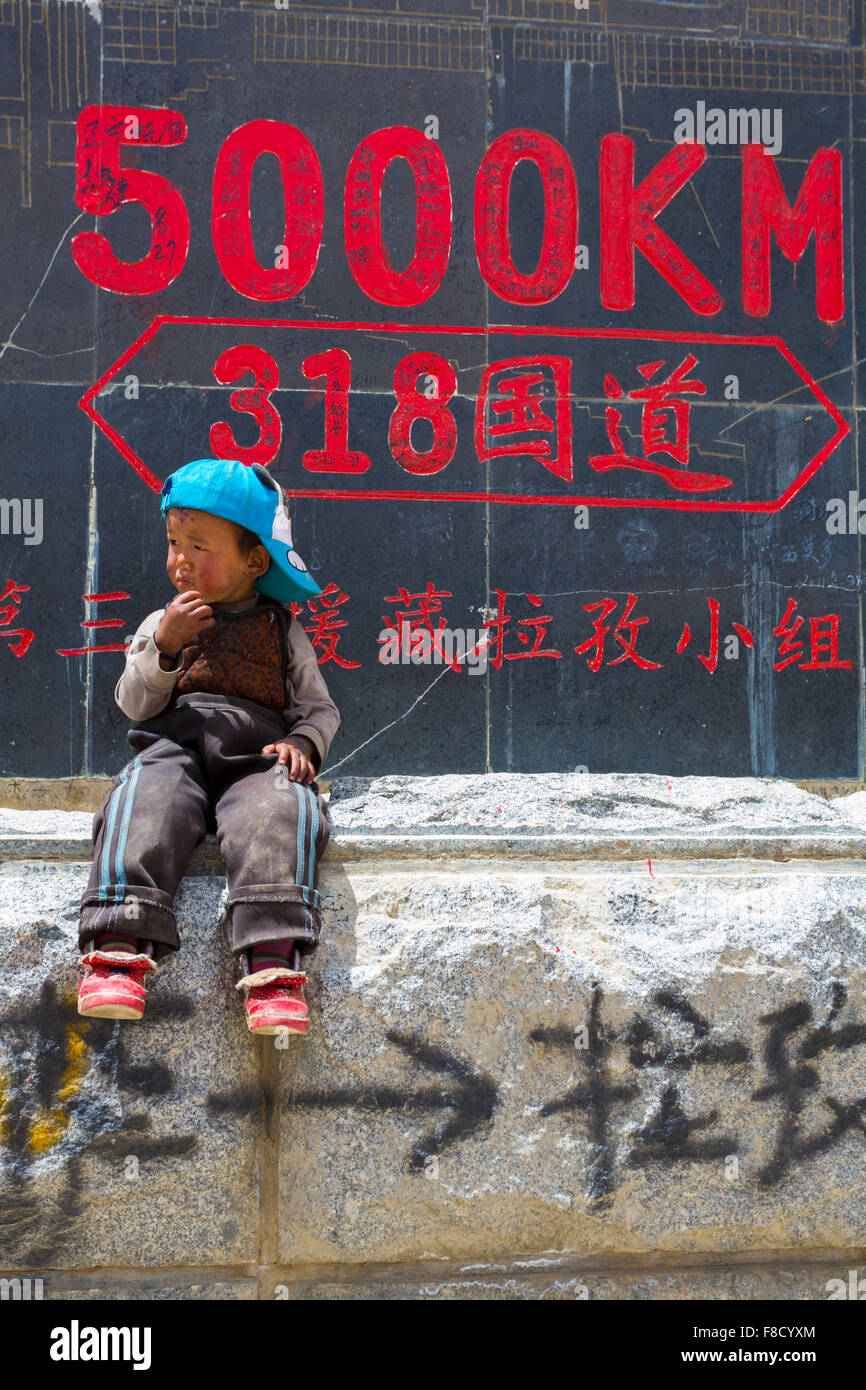 Kid in front off roadsign, Tibet Stock Photo