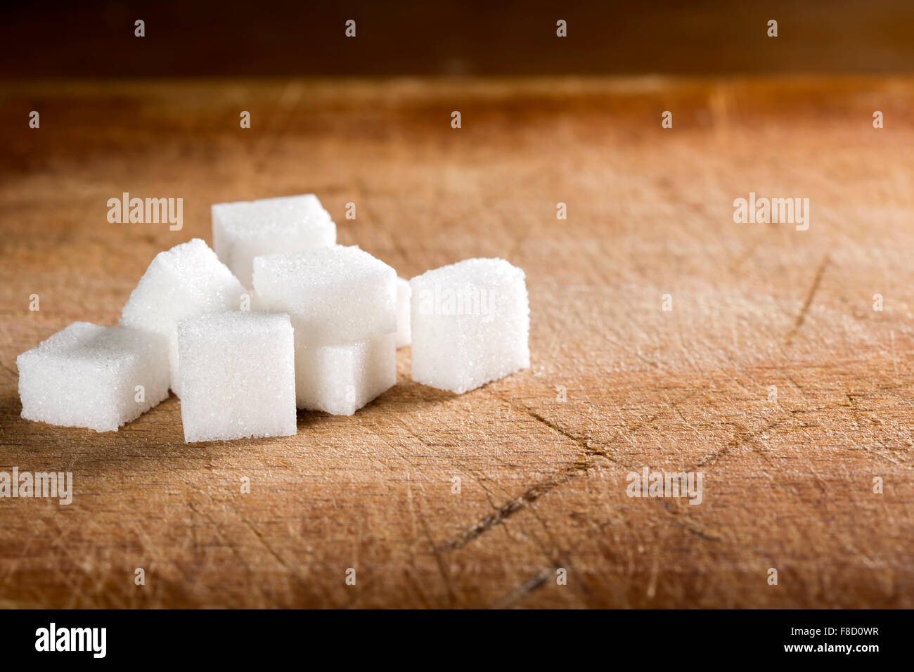 White sugar cubes on old wooden table Stock Photo