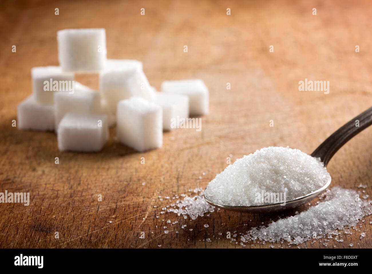 White sugar in silver spoon on wood table Stock Photo