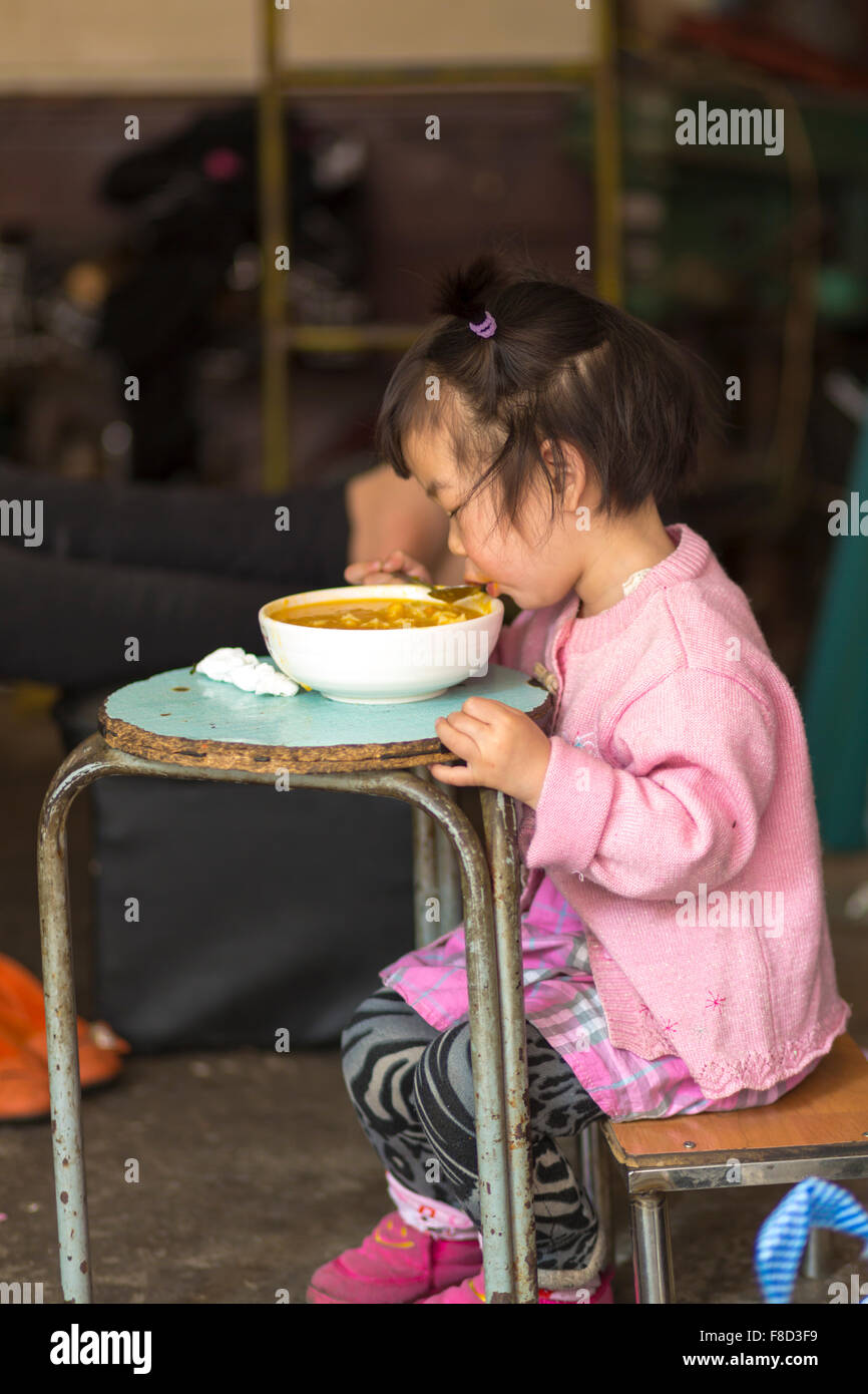 Young girl Eating on a blue table in Shanghai Stock Photo
