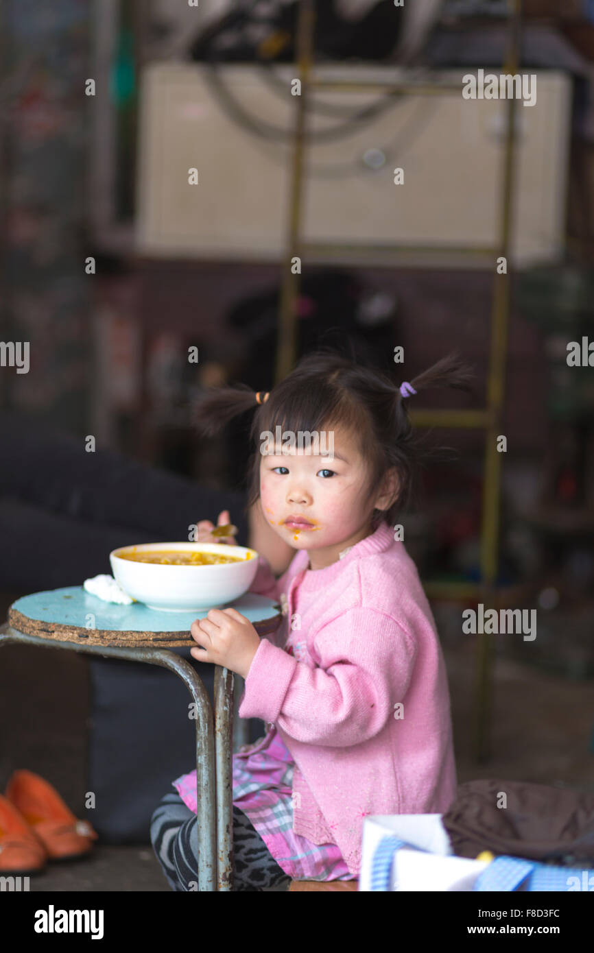 Young girl Eating on a blue table in Shanghai Stock Photo