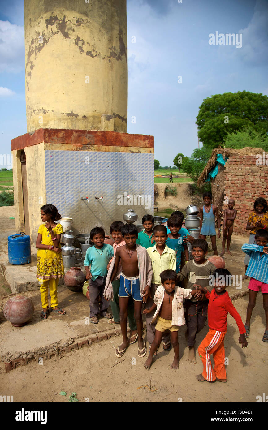 children posing in front of a Water point in India Stock Photo