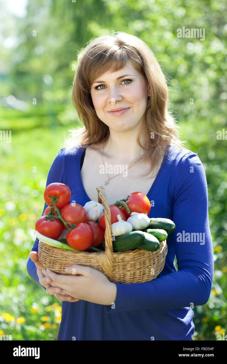 Happy young woman with vegetables harvest in garden Stock Photo - Alamy