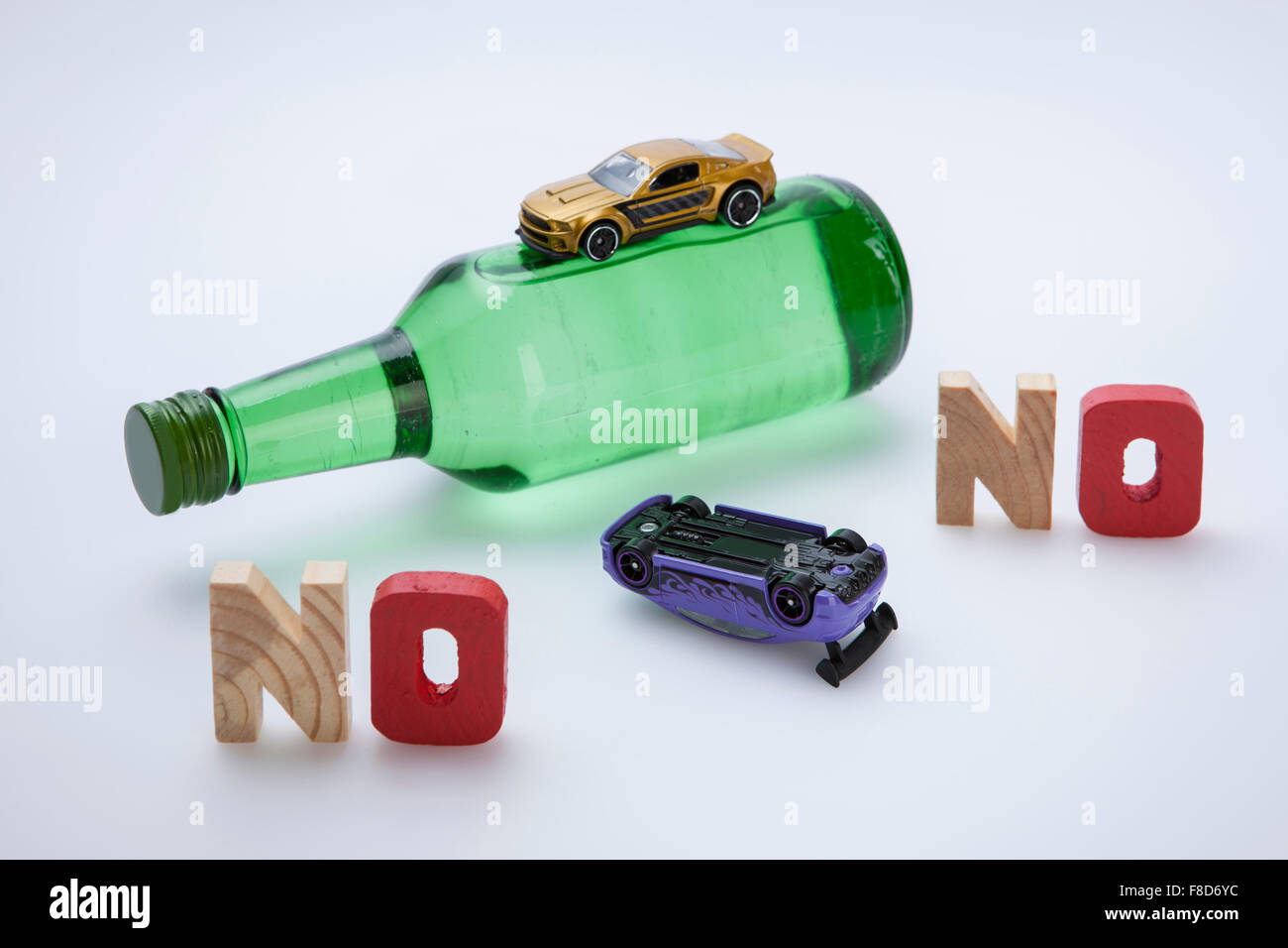 Solid word NO made of wood standing with a bottle of alcohol and