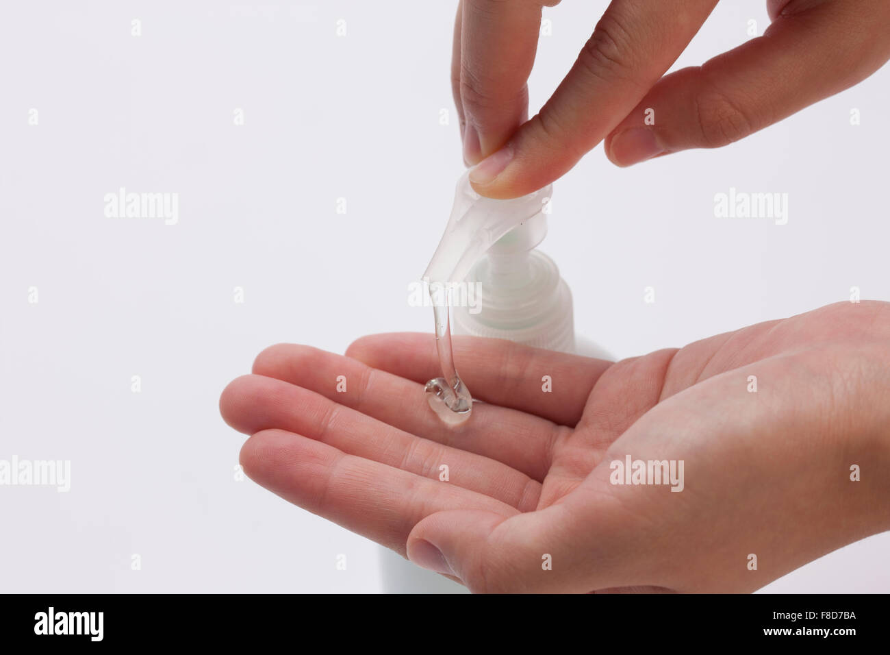 Hand sanitizer being pushed and some liquids coming out from it to a hand Stock Photo