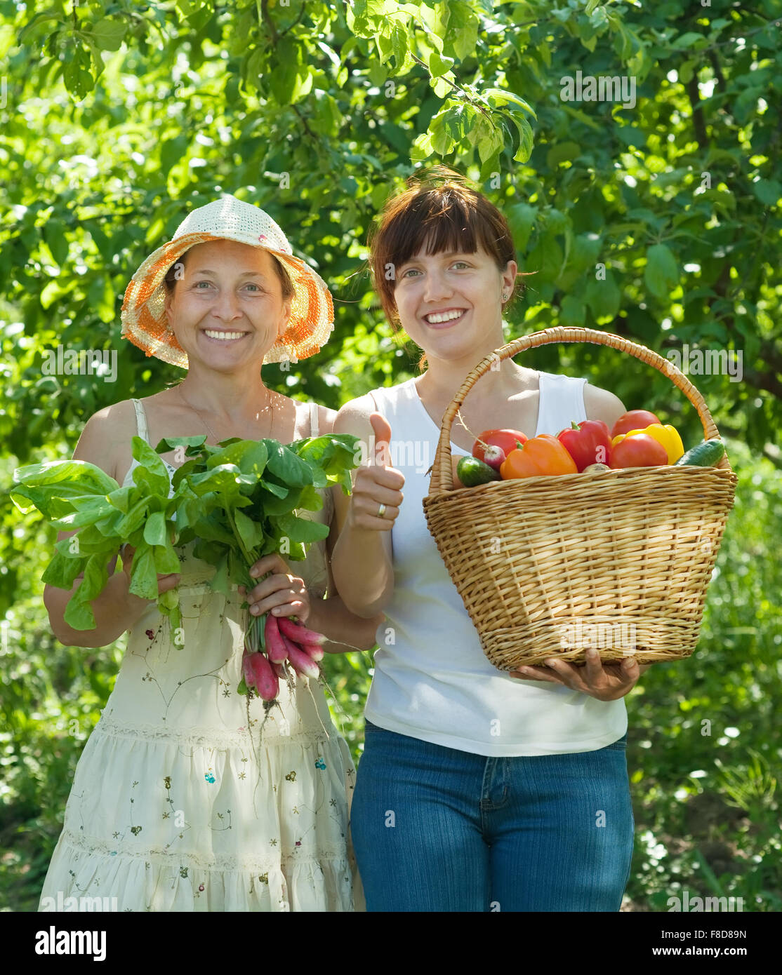 Two happy women with harvested vegetables in garden Stock Photo - Alamy