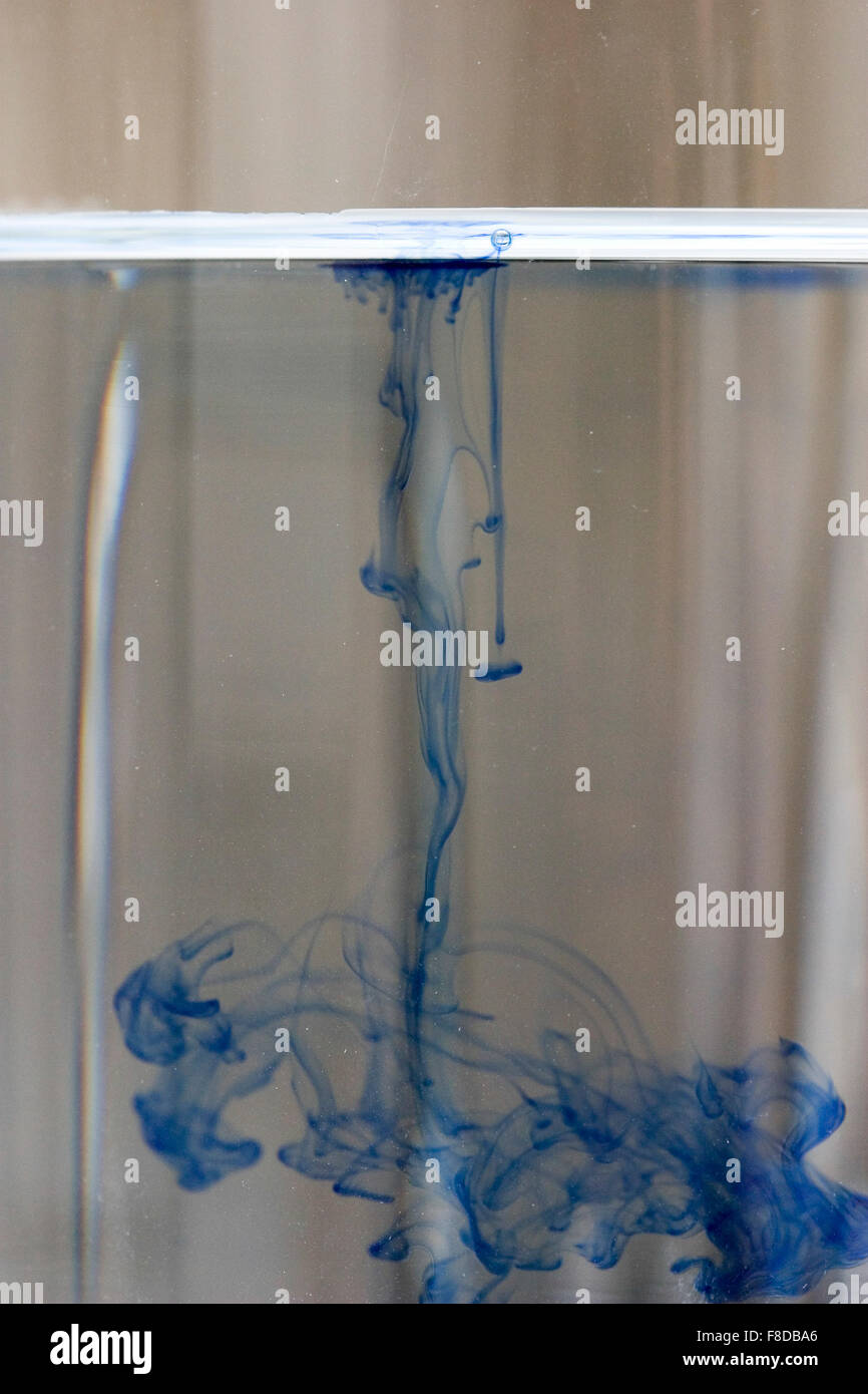 Drop of blue dye diffusing through water. Number four of four in diffusion series. Stock Photo