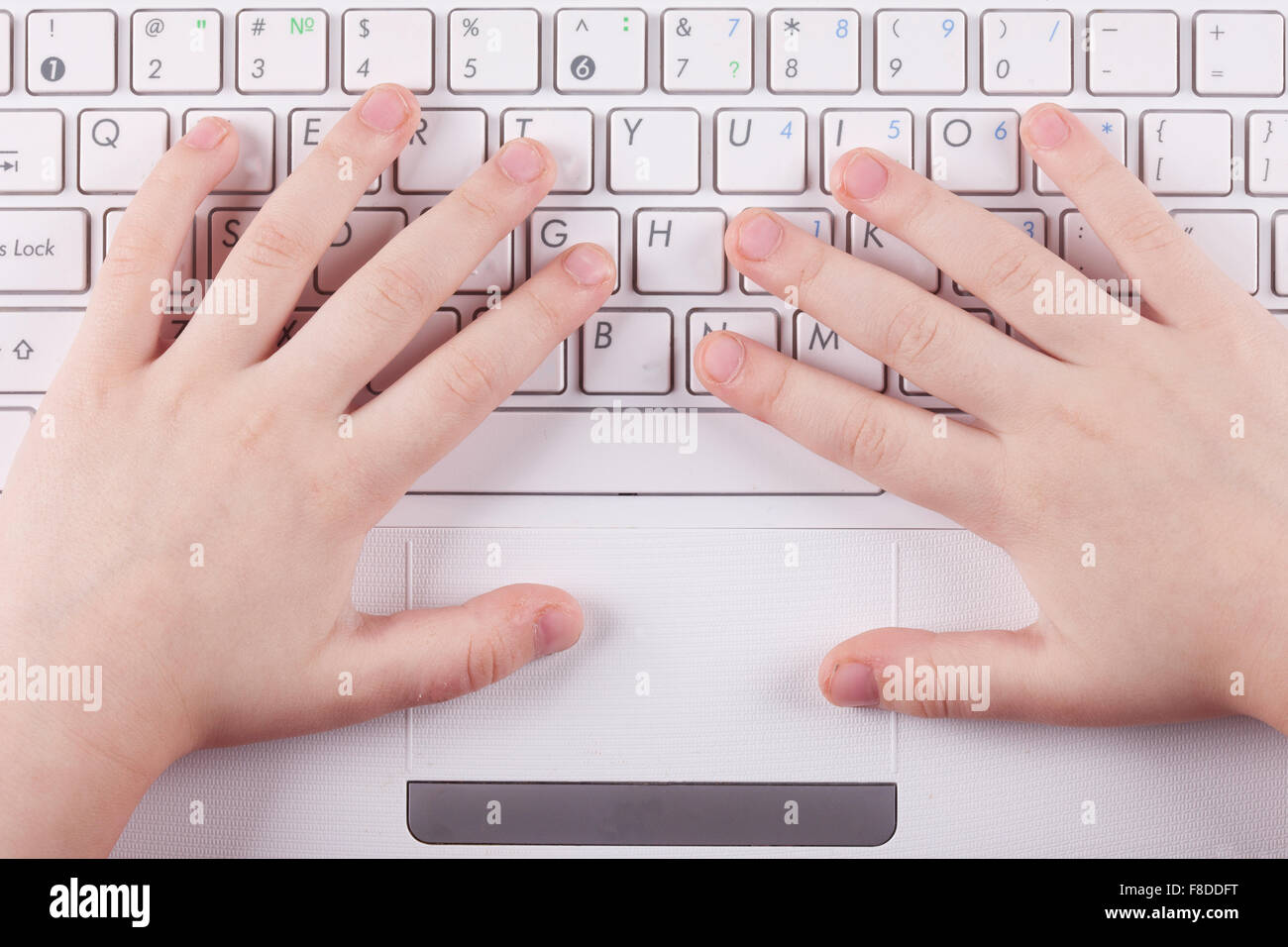 the child's hand on computer keyboard top view closeup Stock Photo