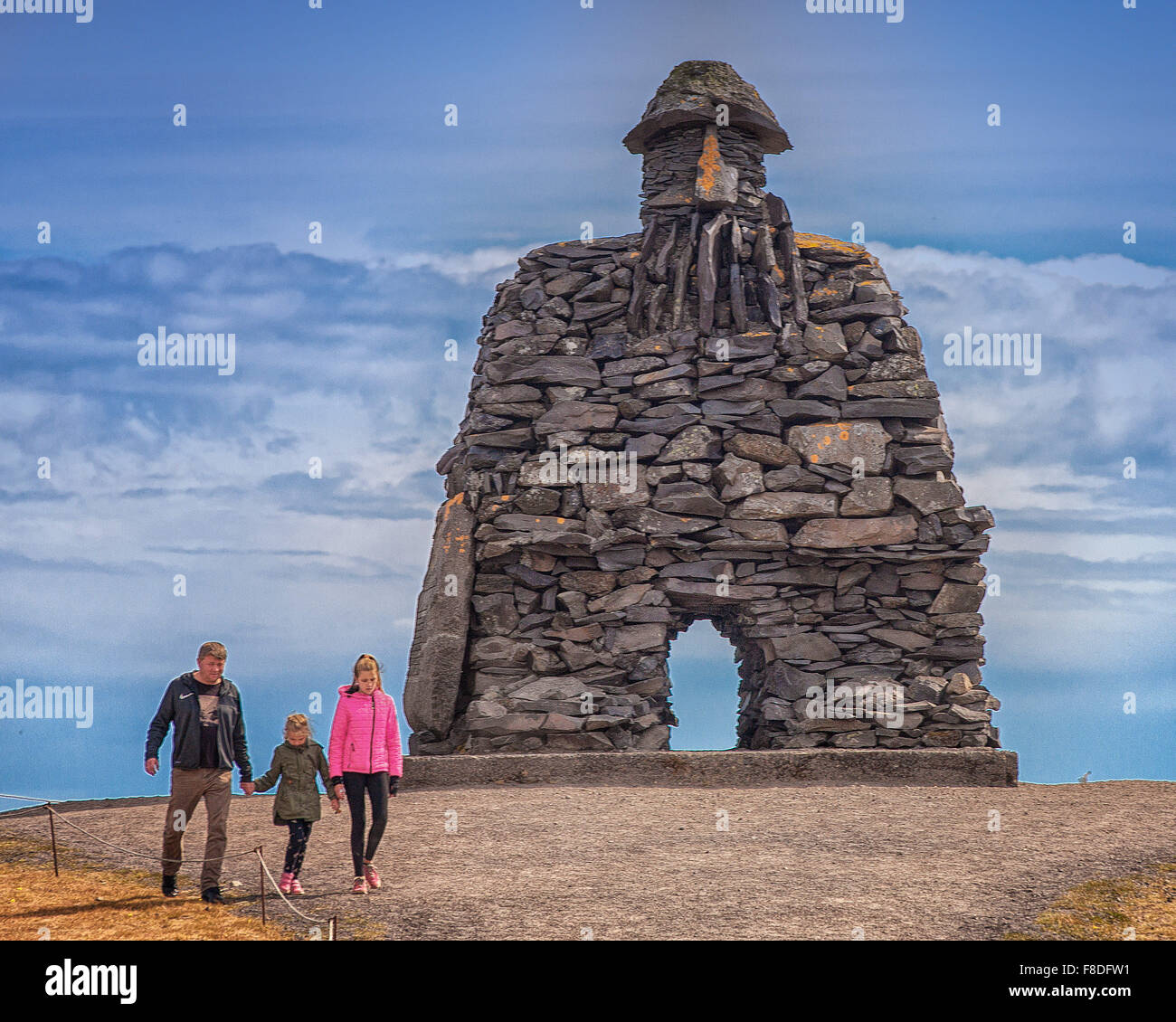 Arnarstapi, Snaefellsnes Peninsula, Iceland. 30th July, 2015. A visitor and his two daughters at the huge stone structure of Bardur SnaefellsÃ¡s at Arnarstapi on the Snaefellsnes peninsula in West Iceland. By sculptor Ragnar Kjartansson, it relates to a late Icelander saga with legendary elements dating to the early 14th century. It is a favorite tourist destination. © Arnold Drapkin/ZUMA Wire/Alamy Live News Stock Photo