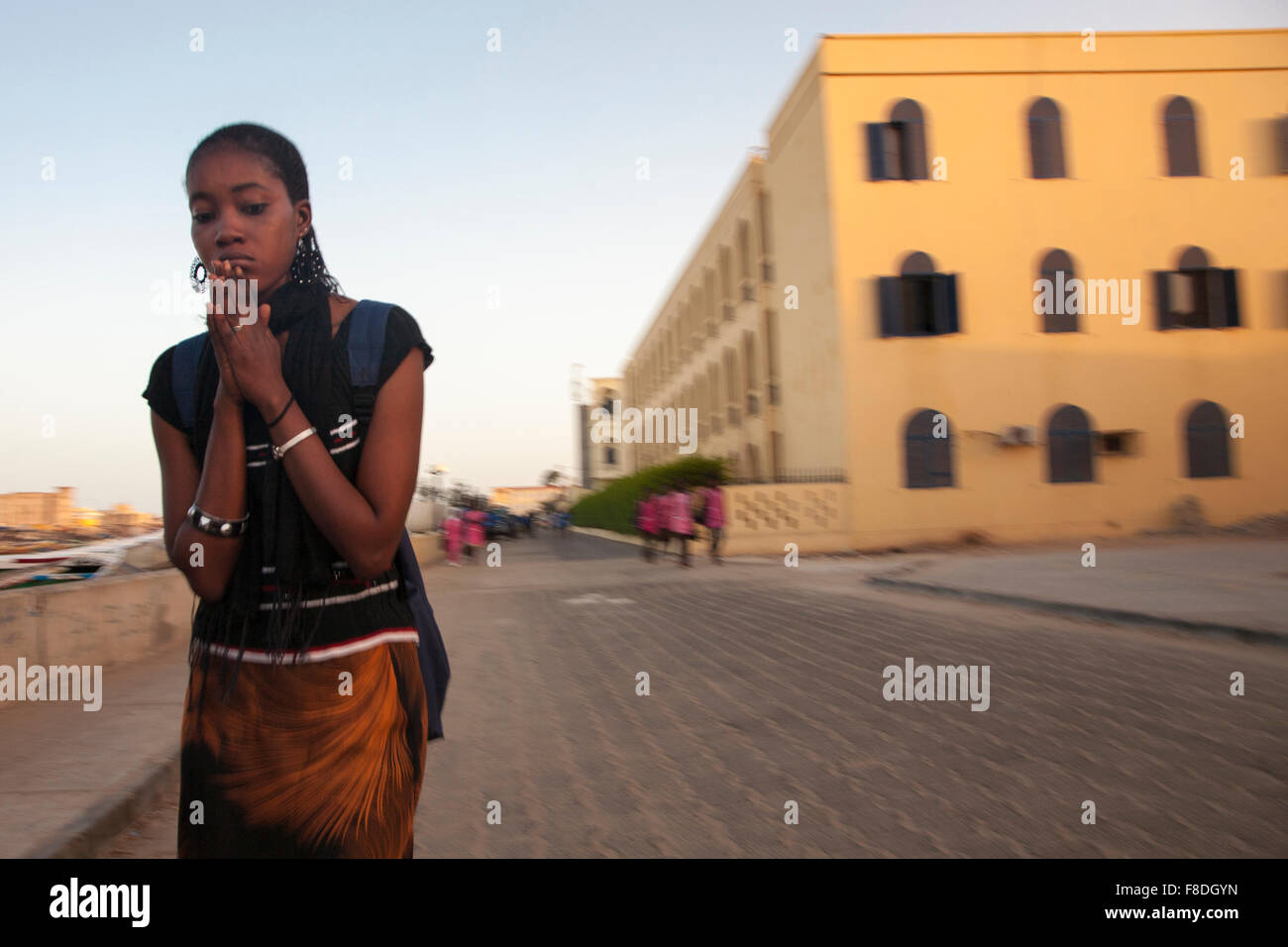 African woman praying in the street of Saint Louis Stock Photo