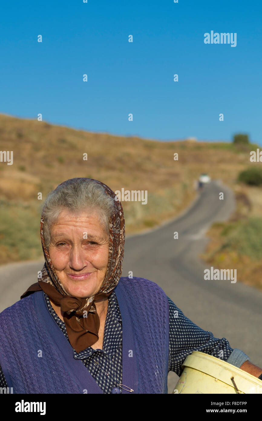 Old traditional greek woman walking with a sweet smile in Greece Stock Photo