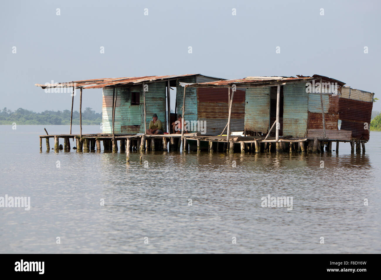 Fisher men sitting in poor wooden houses lifted up on Maracaibo Lake, Venezuela Stock Photo