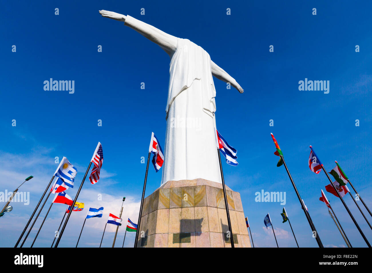 Cristo del Rey statue of Cali against a blue sky with international flags waving around. Colombia Stock Photo