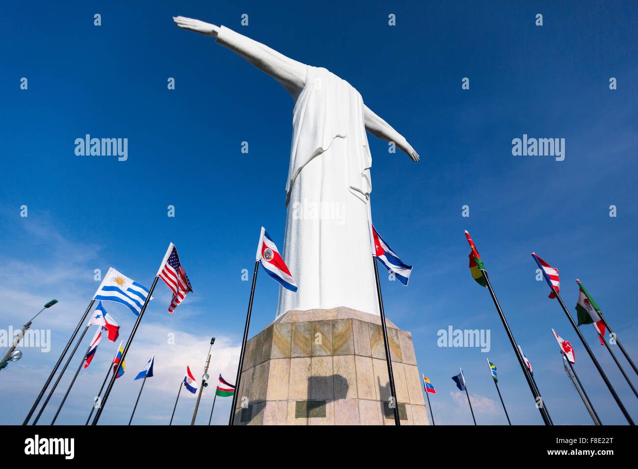 Cristo del Rey statue of Cali against a blue sky with international flags waving around. Colombia Stock Photo