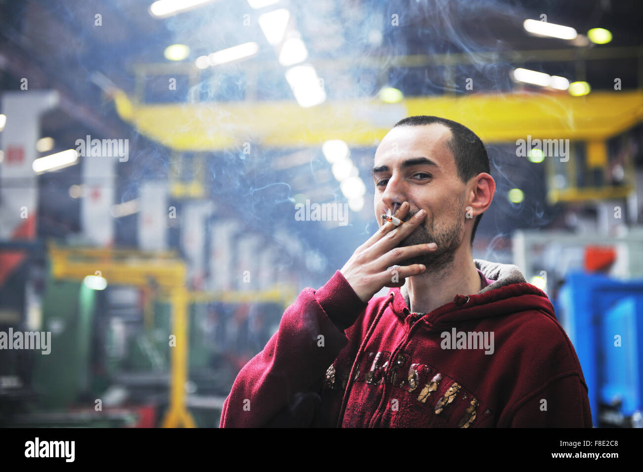 industry worker smoke cigarette at job in company at big bright hall Stock Photo